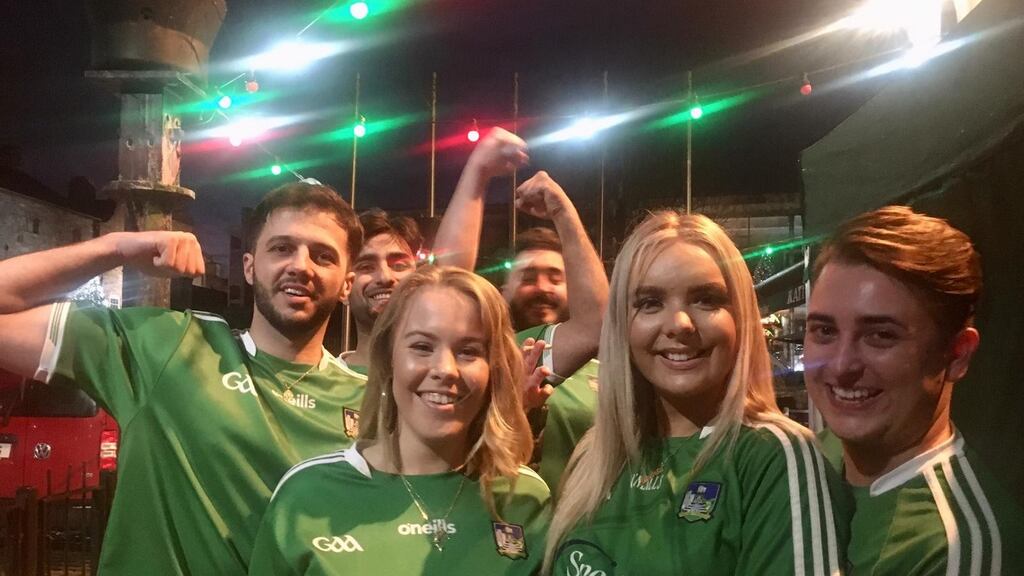 Vullnet Halimi, Halal Hussain, Sarah O’Gorman, Sean Nolan, Saoirse Cooney and Luke Brennan celebrate Limerick’s All-Ireland victory outside Katie Daly’s bar in Limerick. Photograph: David Raleigh