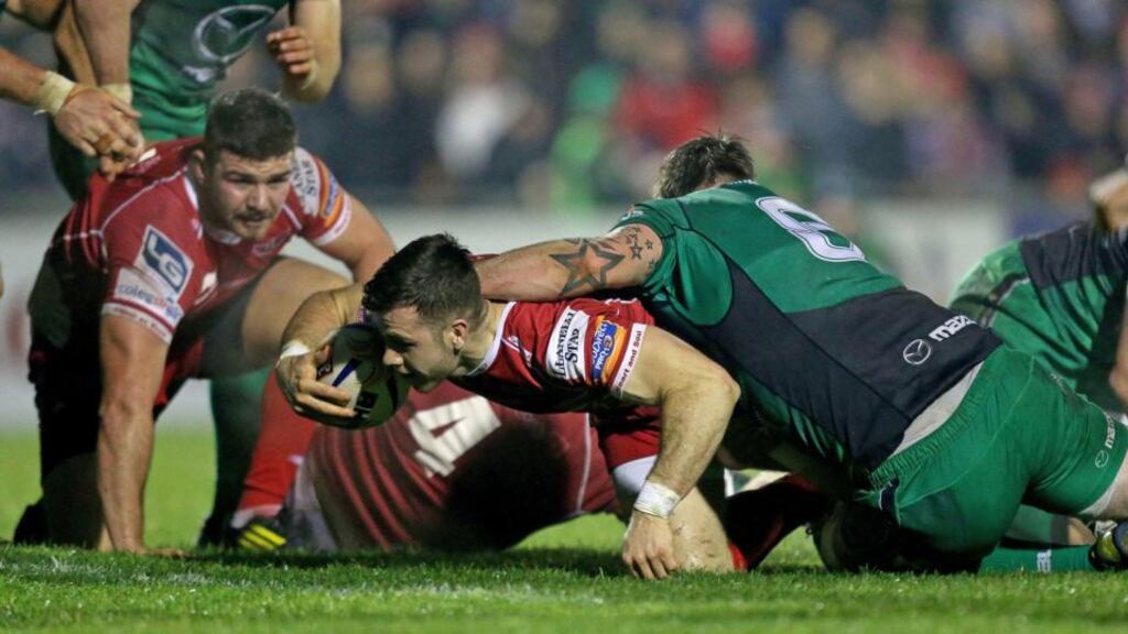 Gareth Davies scores a try for the Scarlets despite the efforts of Aly Muldowney of Connacht. Photograph: James Crombie/Inpho