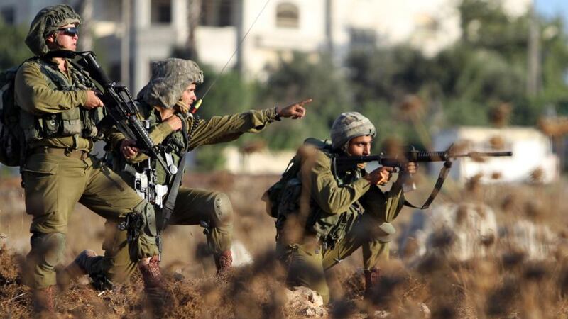 Israeli soldiers watch Palestinian protesters during clashes near the Jalazoun Palestinian refugee camp. Photograph: Abbas Momaniabbas/AFP