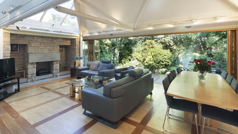 Pavilion living area with vaulted ceilings and a wall of folding glass  that opens out to the teak external deck