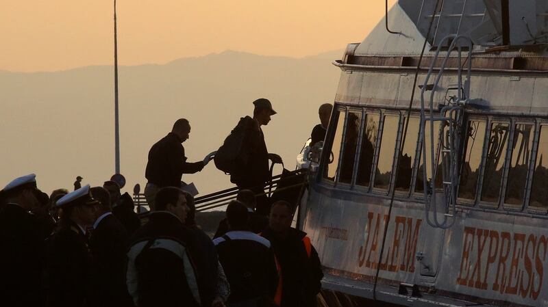 A migrant is escorted by a Frontex officer into a ferry in the port of Mytilene, Lesvos Island, Greece, Monday. Some 160 migrants, from Pakistan, Bangladesh and Morroco, who refused to apply for asylum, were deported early on Monday, after an agreement between the European Union (EU) and Turkey on the refugees crisis. Photograph: EPA