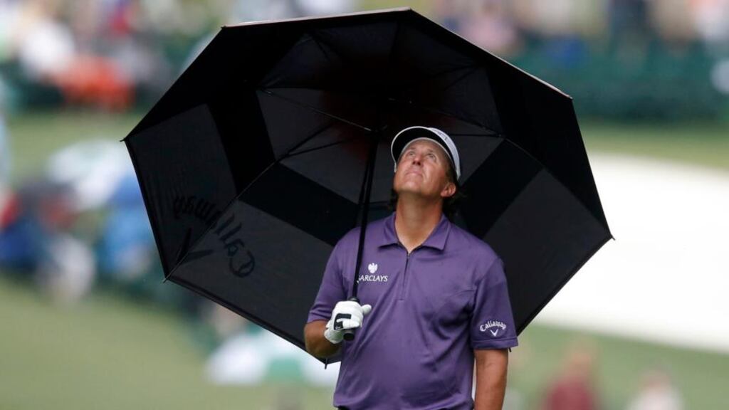 Phil Mickelson stands under an umbrella as he waits to hit his approach shot to the the first green during second round play in the 2013 Masters at Augusta National.  Photograph: Phil Noble/Reuters