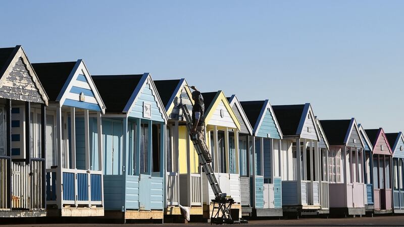A man paints beach huts along the sea front at Southwold in Suffolk, as the UK experienced its warmest winter day since records began with temperatures hitting 20.8C in Porthmadog, Gwynedd, west Wales on Tuesday: Photograph: Joe Giddens/PA Wire
