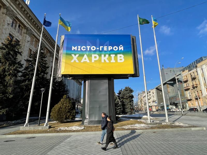 People pass a billboard that states 'Hero city Kharkiv'. Photograph: Daniel McLaughlin