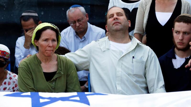 Rachel (front left) and Avi (second right) Fraenkel, parents of US-Israeli national Naftali (16) one of three Israeli teenagers who were abducted and killed in the occupied West Bank, mourn near the Israeli flag-covered body of their son during a memorial service before his funeral, in the central Israeli village of Nof Ayalon today. Photograph: Reuters
