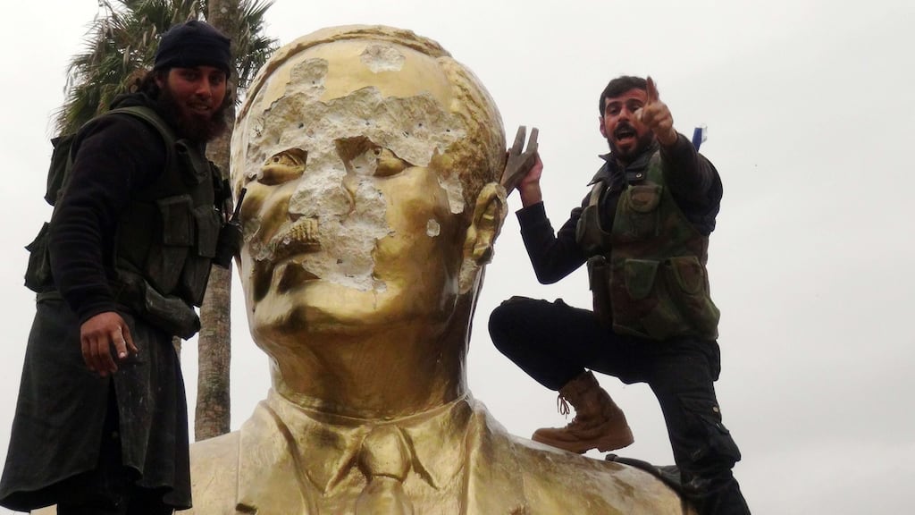 Fighters loyal to al-Qaeda’s Syrian affiliate, Tahrir al-Sham (then known as Jabhat al-Nusra) and its allies smash a statue of the late Syrian president Hafez al-Assad in Idlib in March 2015. Photograph: Sami Ali/AFP/Getty