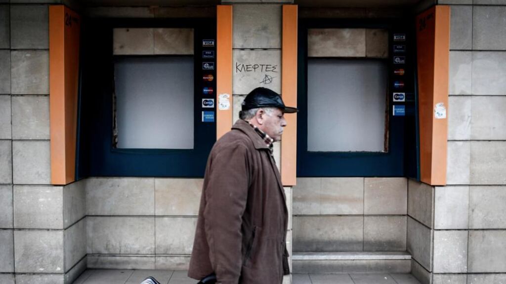 A man walks past a closed branch of the Bank of Cyprus in Nicosia. Photograph: Angelos Tzortzinis/The New York Times