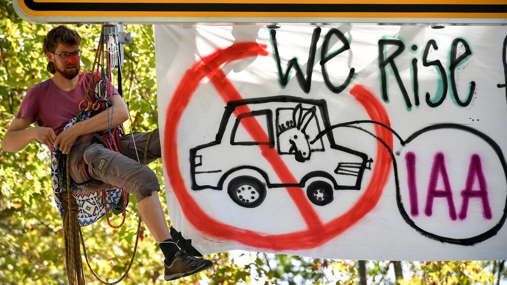 A climate activist fixes a hammock between street signs during a demonstration against climate change in Frankfurt, Germany, on Sunday. Photograph: Sascha Steinbach/EPA