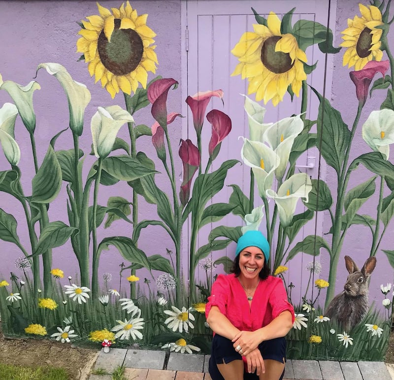 Vauney Strahan with one of her murals on a garden shed
