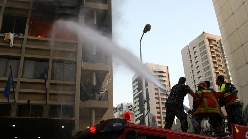 Lebanese firefighters extinguish a fire at the Duroy hotel after a Saudi suicide bomber blew himself up inside his room as security forces were raiding the hotel, in Al Rawcheh area in Beirut, Lebanon