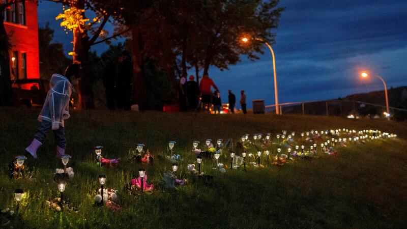 A child outside the former Kamloops Indian Residential School on June 5th after flowers and cards were left to honour the 215 children whose remains were buried in the school grounds. Photograph: Cole Burston/AFP via Getty Images