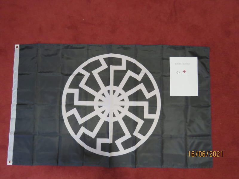 A black flag depicting the Sonnenrad or Black Sun, a popular neo-Nazi symbol