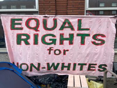 A sign made by international protection migrants hangs outside the International Protection Office. Photograph: Nathan Johns