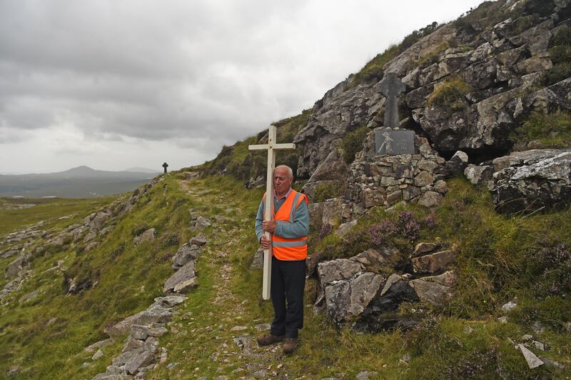 Pádraig Laffey from the parish of Clonbur-Cornamona carries the cross during the Stations of the Cross on the Mán Éan pilgrimage. Photograph: Conor McKeown