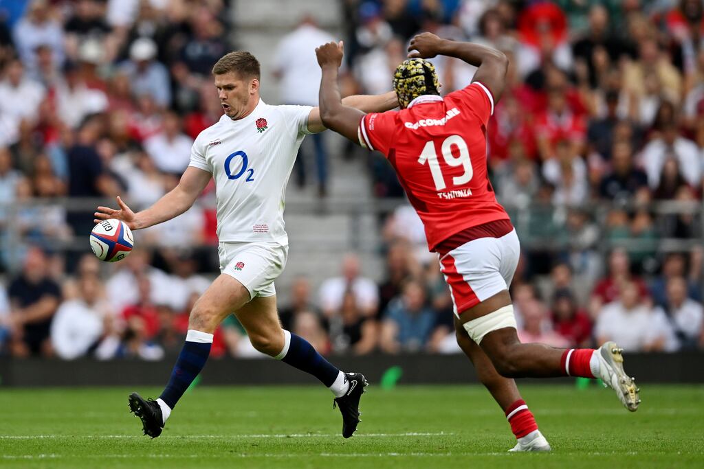 Owen Farrell of England clears the ball whilst under pressure from Christ Tshiunza of Wales. Photograph: Shaun Botterill/Getty