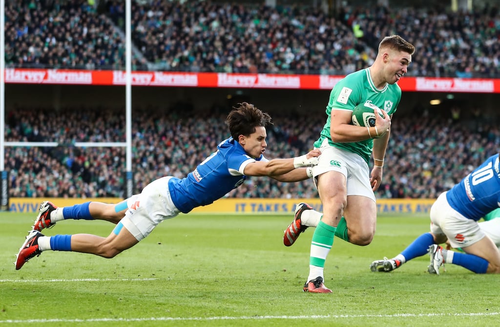 Ireland’s Jack Crowley scores the opening try of the game despite the efforts of Italy's Ange Capuozzo at the Aviva Stadium. Photograph: Ben Brady/Inpho