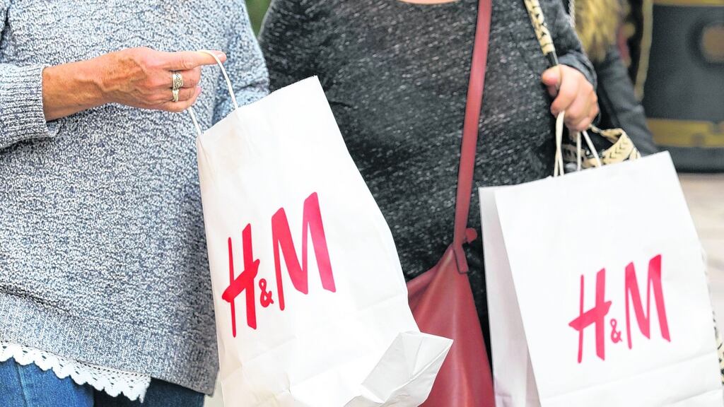 Shoppers hold branded H&M clothing store bags in London.