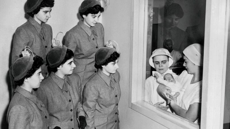 The Dionne quintuplets look at a premature baby at St. Vincent’s Hospital, in New York in  1950. Photograph: Ernie Sisto/New York Times