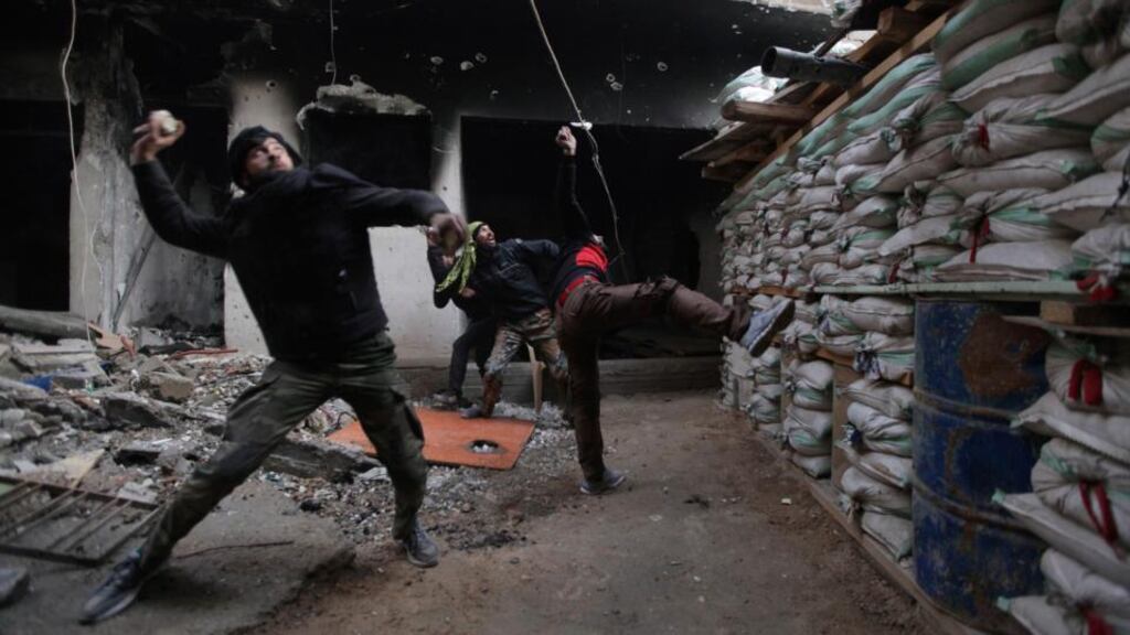 Free Syrian Army fighters throw stones towards forces loyal to Syria’s president Bashar Al-Assad in Deir al-Zor, eastern Syria, on Saturday. Photograph: Reuters/Khalil Ashawi
