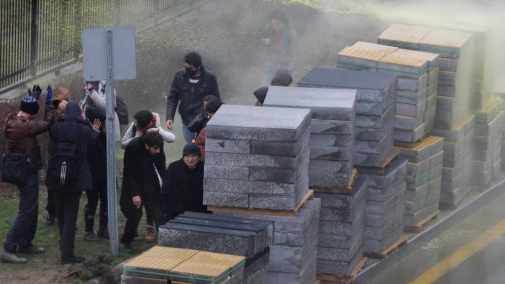 People take cover as riot police fire water cannons to disperse demonstrators marching along a main highway to protest the death of Berkin Elvan in Ankara today. Photograph: Umit Bektas/Reuters