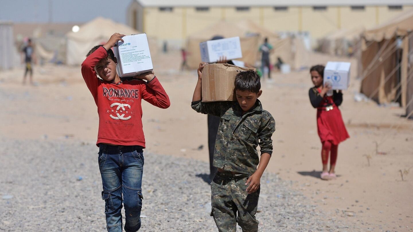 Iraqi displaced people from Syria receive aid supplies at a refugee camp in Baiji, north of Baghdad on Friday. Photograph: Reuters