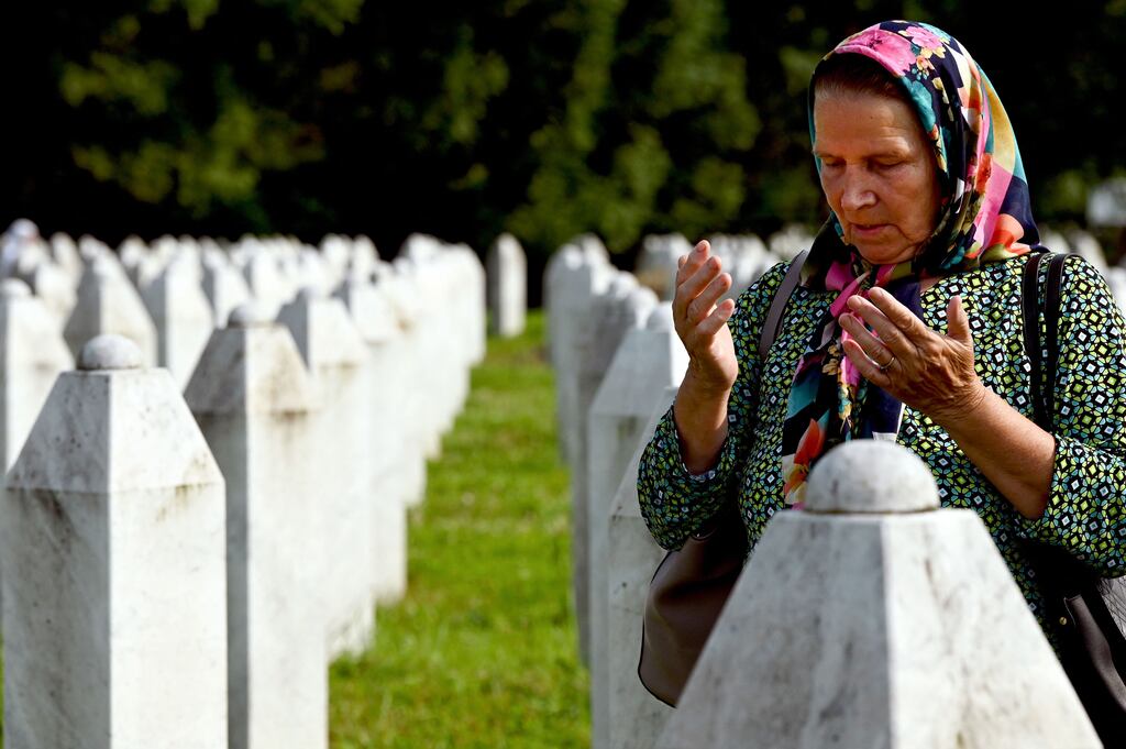 A Bosnian Muslim woman mourns near the graves of relatives and victims of the Srebrenica massacre, at the memorial cemetery in the village of Potocari, near Eastern-Bosnian town of Srebrenica. Photograph: Elvis Barukcic/AFP via Getty Images