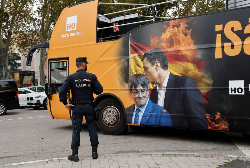 A bus set to carry protesters bears a combination of pictures depicting Catalan leader Carles Puigdemont and Spain's acting prime minister Pedro Sánchez . Photograph: Oscar Del Pozo/AFP via Getty Images