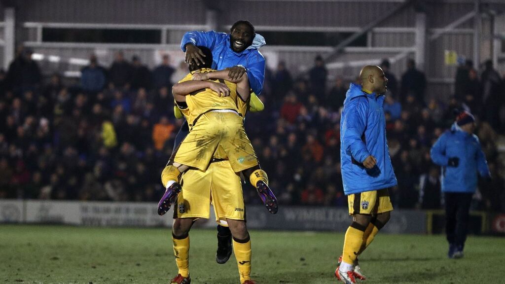 Sutton United’s Maxime Biamou celebrates with teammates after they shocked AFC Wimbledon to advance to the FA Cup fourth round. Photo: Adrian Dennis/Getty Images