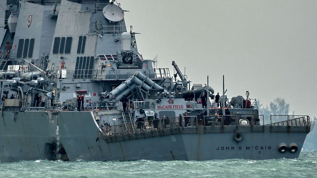 The guided-missile destroyer USS John S McCain, with a hole on its portside after a collision with an oil tanker, making its way to Changi naval base in Singapore on August 21st. The bodies of 10 sailors who died in the accident have been recovered. Photograph: Roslan Rahman/AFP/Getty Images