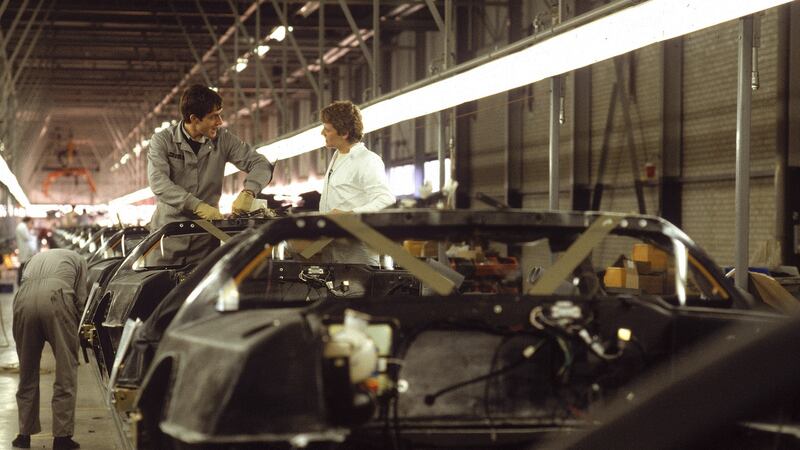 Two workers on the assembly line at the DeLorean Motors factory talk while a third checks a wheel base in November 1981. File photograph: Bill Pierce/Life/Getty