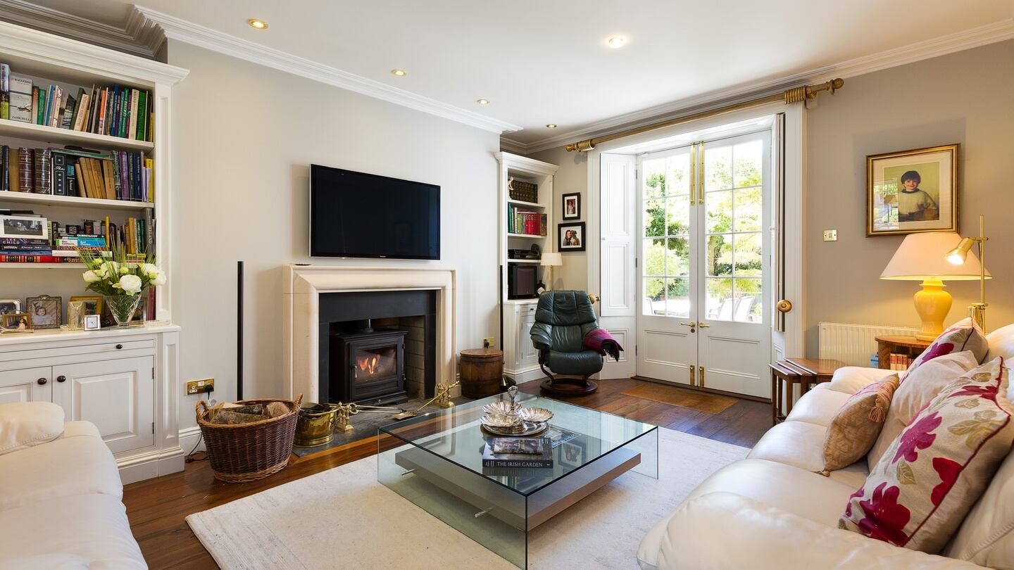A smart livingroom off kitchen at ground level leads through French windows to the patio