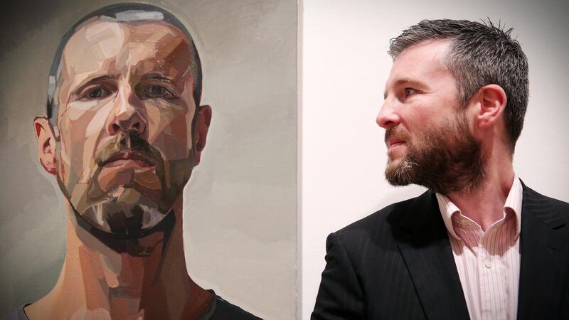 Local artist Gavan McCullough is pictured with his self portrait at the exhibition which is among the pieces on display at the BP Portrait Award exhibition which opens at the Ulster Museum in Belfast on Friday. Photograph: Kelvin Boyes/Press Eye.
