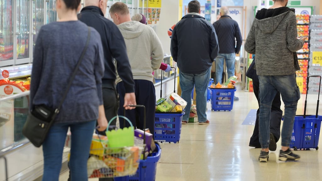 Customers in Tesco in Rush stand on two-metre markers when queuing for the checkouts. The British supermarket chain this week said it would take a €1 billion hit from the costs of dealing with the pandemic. Photograph: Alan Betson/The Irish Times