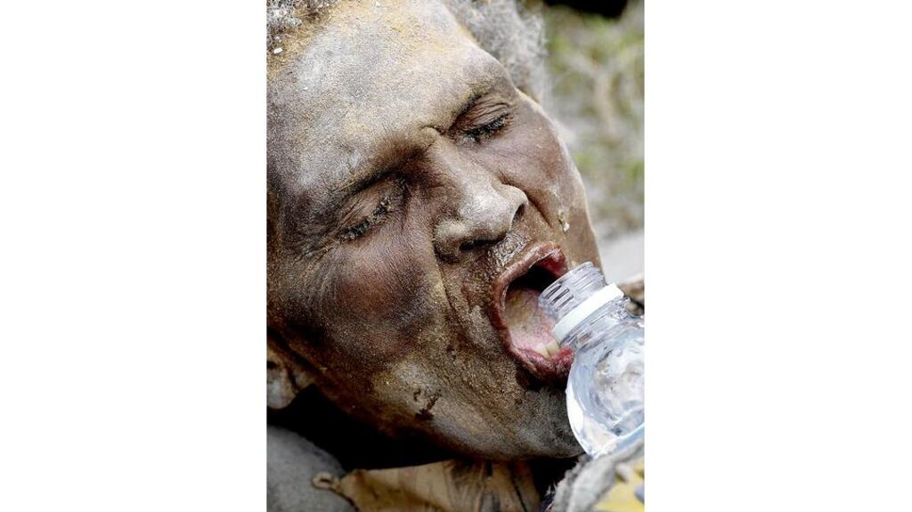Ena Zizi takes a drink of water after being carried alive from the rubble in Port-au-Prince A girl receives water from Sr Patsy of the Missionaries of Charity at a makeshift hospital run by the Belgian first aid and support team in Port-au-Prince yesterday. Photograph: Wolfgang Rattay/Reuters
