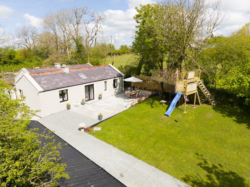 The spacious back garden includes a tree house, slide and swing.