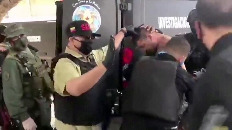Venezuelan soldiers wearing face masks surround a suspect removed from a helicopter after what Venezuelan authorities described as a ‘mercenary incursion’, at an unknown location in this still frame obtained from Venezuelan government TV video. Photograph: Venezuelan government TV/via Reuters