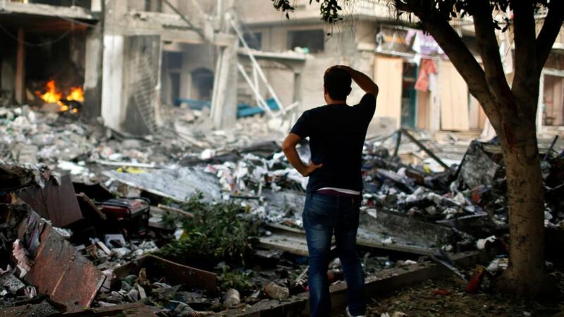 A Palestinian man surveys the burning rubble of a house in Gaza City which police said was hit in an Israeli air strike. Photograph: Mohammed Salem/Reuters