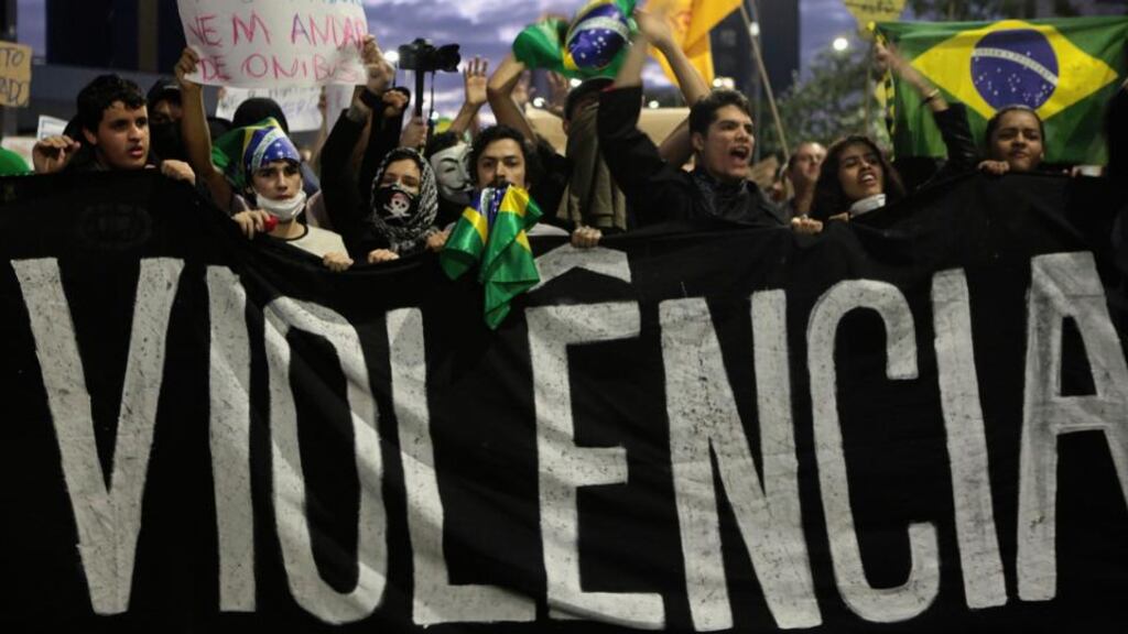 Demonstrators shout anti-government slogans behind a banner, which reads as ‘violence’, during a protest in Sao Paulo yesterday. Photograph: Reuters