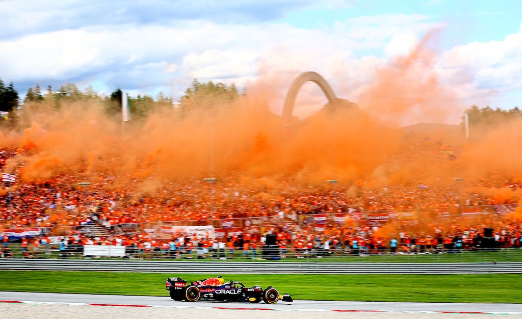 Max Verstappen supporters let off orange smoke bombs as the Dutch Red Bull driver waves following his win in the sprint race at the Austrian Grand Prix in Spielberg. An estimated 60,000 fans have travelled from the Netherlands for the race. Photograph: Clive Rose/Getty Images