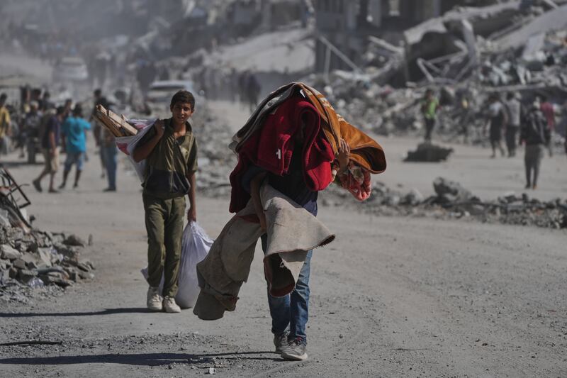 Palestinians carry their belongings along Al-Jalaa Street in Gaza City. Photograph: Abdel Kareem Hana/AP