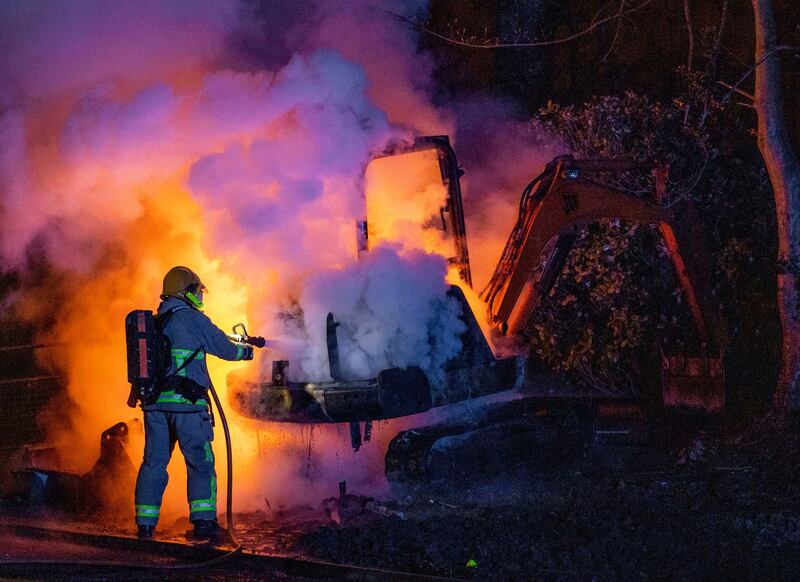 FLAME OUT: A member of the Northern Ireland Fire and Rescue Service extinguishes a blaze in a digger set alight on Monday night close to the loyalist Nelson Drive Estate in the Waterside of Derry City, Co Derry, amid continuing violence in loyalist areas of Northern Ireland. Photograph: Liam McBurney/PA Wire