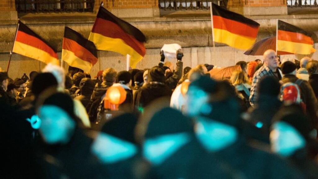 ‘In Germany establishment parties have ruled out co-operation with Pegida, the German acronym for “Patriotic Europeans Against Islamisation of the West”.’ Supporters of the Pegida movement waves flags while they gather for a march in their first Berlin demonstration,  following  marches in Dresden.  Photograph:  Carsten Koall/Getty Images