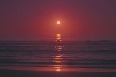 Surfing in the sunset at Caparica beach, Lisbon