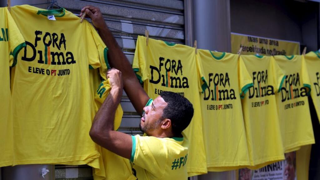 A vendor hangs shirts reading “Out, Dilma” during a protest against Brazil’s president Dilma Rousseff over a corruption scandal at Petrobras. Photograph: Reuters
