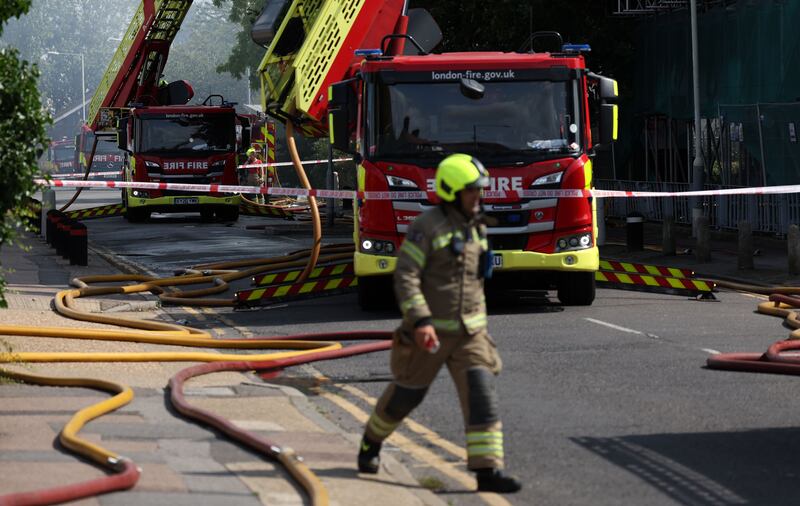 Firemen on the site of fire at a block of flats in Dagenham in east London. Photograph: Andy Rain/EPA