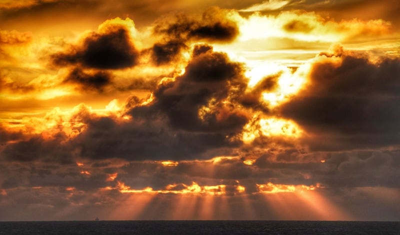 A ferry on the horizon sails under stormy skies and sunlight off the coast of Whitley Bay, England. Photograph: Owen Humphreys/PA Wire
