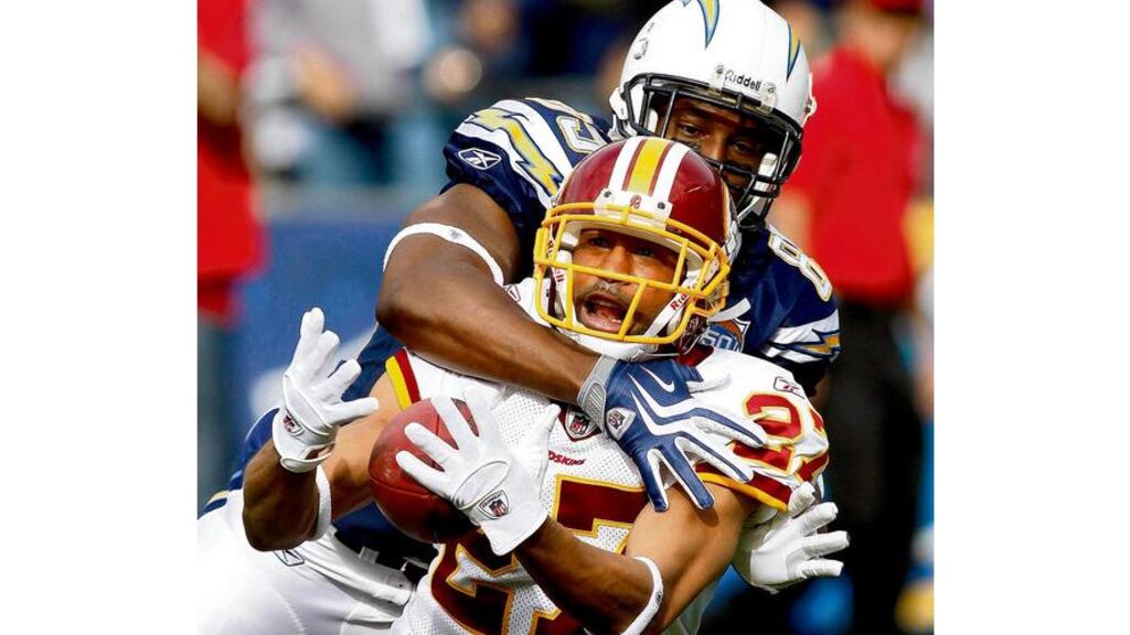 Washington Redskins cornerback Fred Smoot (27) tries to make an interception but is hit by San Diego Chargers tight-end Antonio Gates and loses the ball. - (Photograph: Denis Poroy/AP)