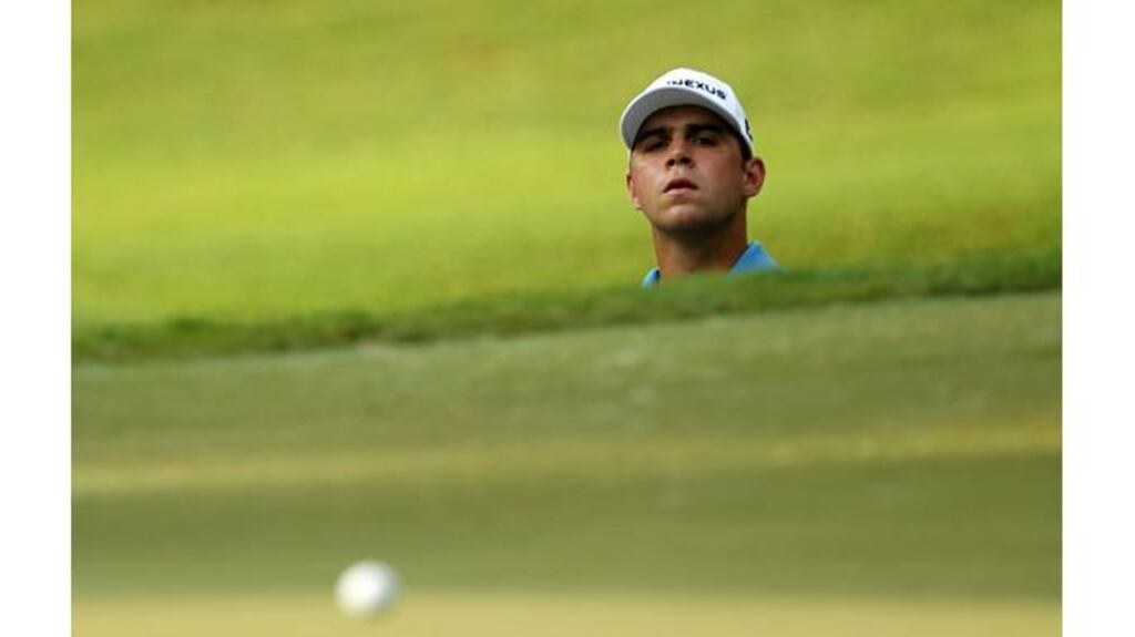 Gary Woodland keeps a watchful eye on his ball after playing from the greenside bunker on the 12th hole today. Photograph: Mike Ehrmann/Getty Images