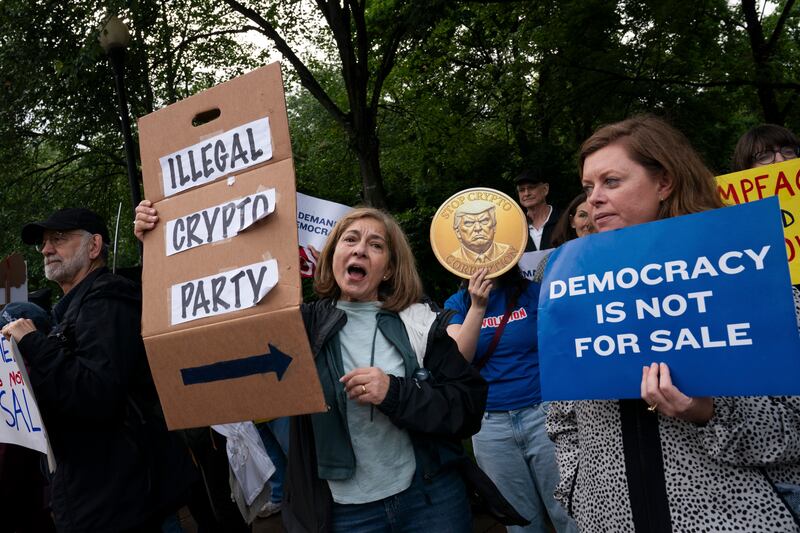 Protesters outside a private dinner with president Donald Trump and buyers of his cryptocurrency at his golf course in Virginia. Photograph: Elizabeth Frantz/The New York Times