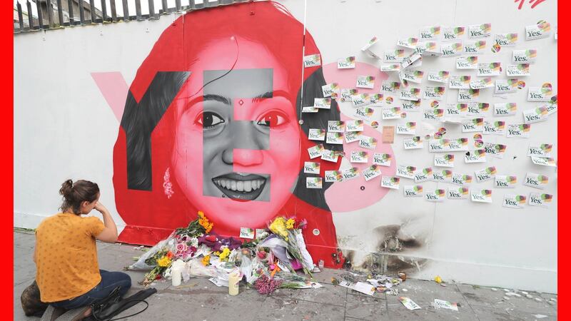 A woman kneels in front of a mural of Savita Halappanavar in Dublin. Photograph: Niall Carson/PA